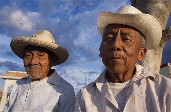 MEXICO, Yucatan, Hoctun, "Two smiling, elderly men in hats, head and shoulder portraits one slightly behind other. "