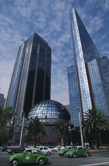 MEXICO, Mexico City, "Financial district in Zona Rosa on Paseo de La Reforma.  Domed roof of bank surrounded by high rise buildings, green volkswagon taxis on road in the foreground. "
