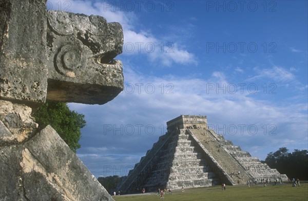 MEXICO, Yucatan, Chichen Itza, Stone carving on the Platform of the Eagles in the foreground with El Castillo behind.