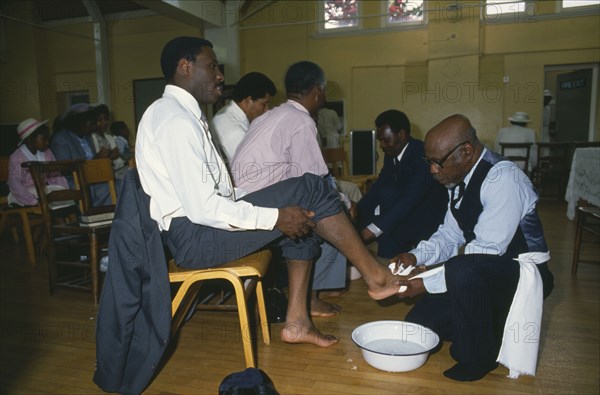 ENGLAND, London, Religion, Pentecostal church service.  Members of the congregation taking part in the washing of feet ceremony.