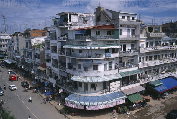 CAMBODIA, Phnom Penh, "City view over converging streets, one well maintained and the other partly destroyed after the Khmer Rouge regime.  Both lined with shops with apartments above "