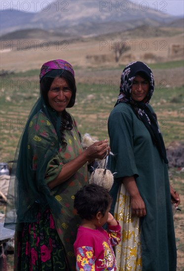 IRAN, Zagros Mountains, "Qashqai nomads on annual immigration through the Zagros Mountains.  Two women and child, three-quarter portrait."