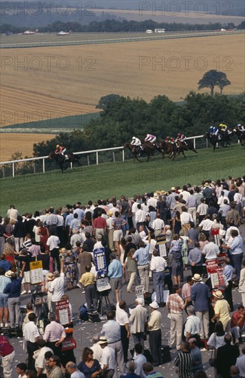 20026915 ENGLAND West Sussex Goodwood Crowds and line of bookmakers watching horse race at Goodwood racecourse on the South Downs.