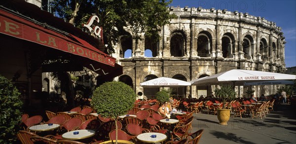 FRANCE, Languedoc-Roussillon, Gard, Nimes.  Cafe with outside tables in front of the Arenes.