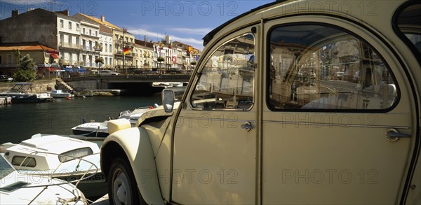 FRANCE, Languedoc-Roussillon, Herault, Sete.  Part view of harbour and waterside buildings with white citroen car in the foreground.