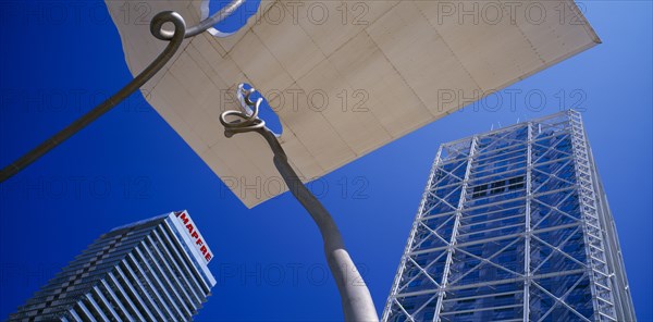 SPAIN, Catalonia, Barcelona, Torre Mapfre and Hotel Arts Barcelona seen from below looking up against blue sky.