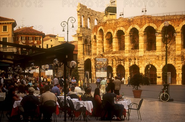 ITALY, Veneto, Verona, Piazza Bra.  Busy cafe with people eating and drinking at outside tables in front of the Arena.