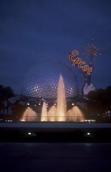 USA, Florida, Orlando, Walt Disney World Epcot. View of the Spaceship Earth with  Epcot sign and fountain illuminated at dusk.