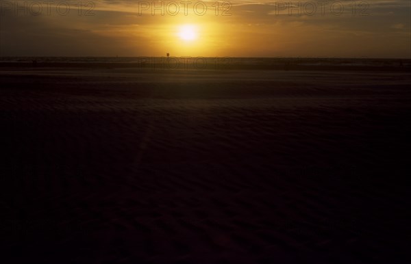 USA, Florida, Clearwater, Clearwater beach at sunset with bright orange sun over the sea.