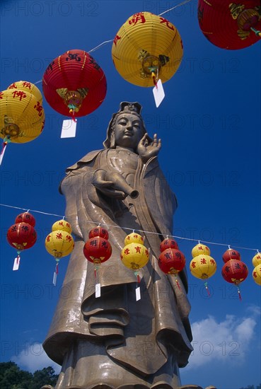 MALAYSIA, Penang, Kek Lok Si Temple, "Bronze statue of Kuan Yin or Avalokiteshvara, the male Bodhisattva, a future Buddha representing the force of creation.  Chinese New Year lanterns in foreground. "