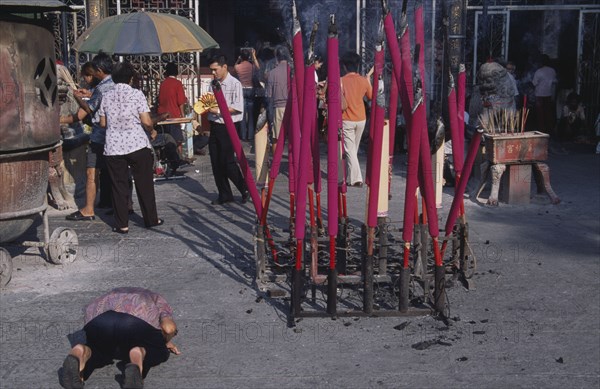 MALAYSIA, Penang, Georgetown, "Goddess of Mercy Temple, also known as Kuan Yin Teng.  Exterior with worshippers and large pink burning incense sticks."