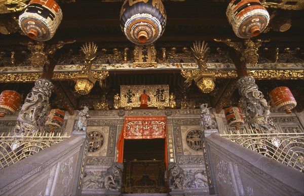MALAYSIA, Penang, Georgetown, "Koo Kongsi, the Dragon Mountain Hall. Exterior of clan house, black and gold ornate decoration around door at top of steps and Chinese lanterns hanging above"