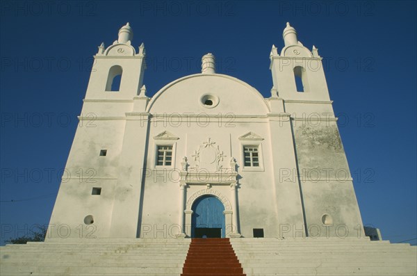 INDIA, Gujarat, Diu, Church of St Thomas.  Exterior view looking up steps toward facade with central painted red line leading to entrance.