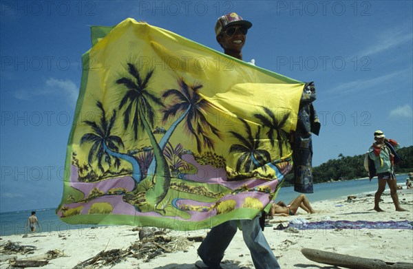 THAILAND, Koh Samui, Chaweng Beach , Sarong Vendor displaying colourful sarong on the beach