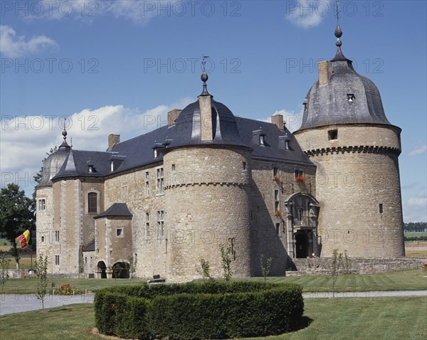 BELGIUM, Ardenne, Lavaux-Sainte-Anne , Medieval Chateau a stone building with a black roof and circular boxed hedge in the foreground