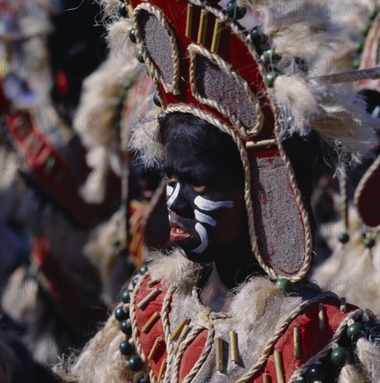 PHILIPPINES, Luzon, Manila, Young girl in costume at Ati-Atihan festival with a black painted face and wearing a headdress