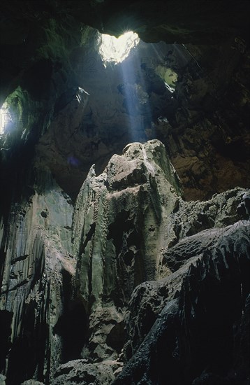 MALAYSIA, Borneo, Kalimantan, Niah Caves interior with light shining through holes in the roof of the cave