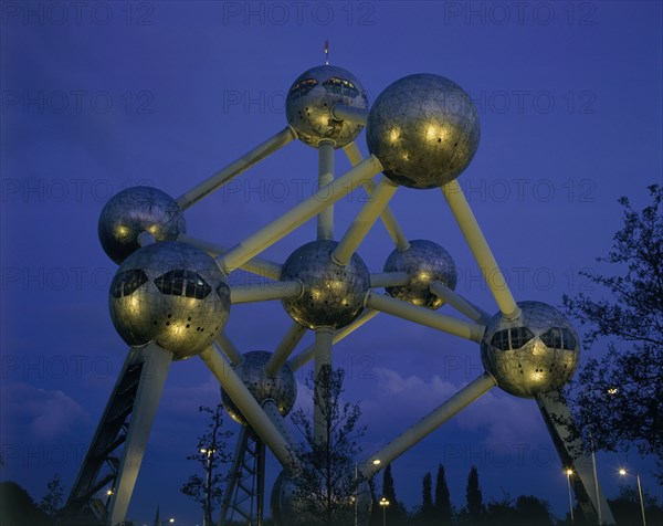 BELGIUM, Brabant, Brussels, The Atomium illuminated at night with lights reflected on the base of the metal spheres