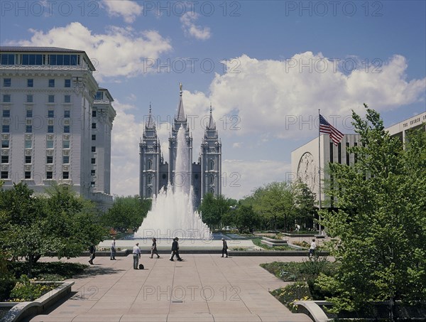 USA, Utah, Salt Lake City, The Mormon Temple beyond the fountain in the gardens with the US flag flying from a flagpole