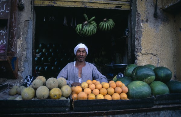EGYPT, Upper Egypt, Luxor, "Fruit vendor outside shop selling green bananas, water melons and oranges"