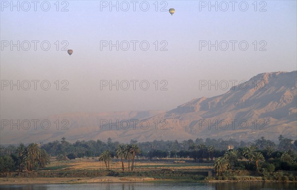 EGYPT, Upper Egypt, Luxor, Valley of the Kings with two hot air balloons over the river Nile at sunrise