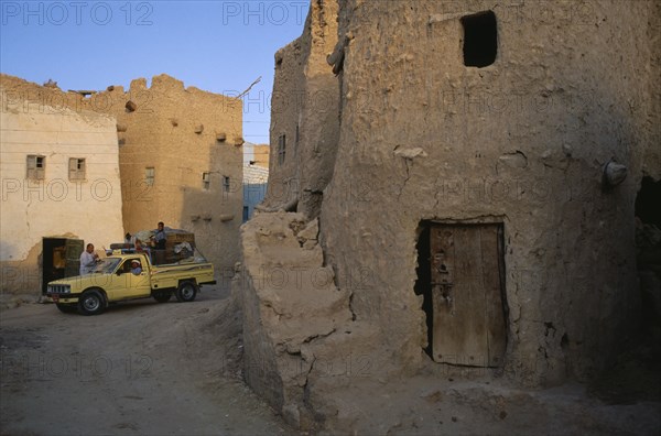 EGYPT, Western Desert, Siwa Oasis, Pick-up truck loaded with people and goods in street below Shali Fortress