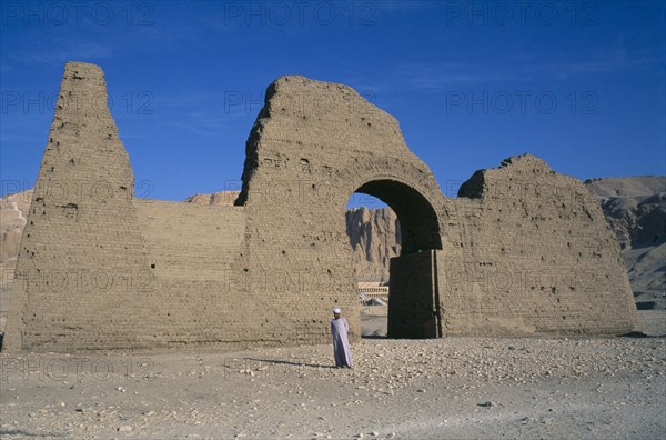 EGYPT, Upper Egypt, Luxor, Temple of Hatshepsut entrance gateway with guide and Temple seen through archway