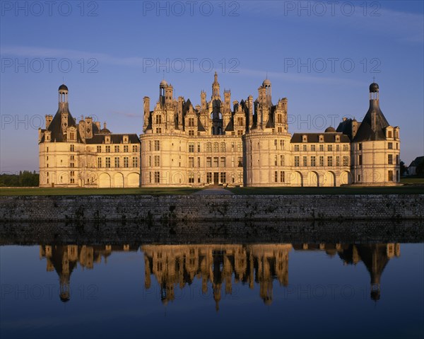 FRANCE, Loire Valley Centre, Loir et Cher, "Chateau Chambord in golden light, reflected in moat in foreground"