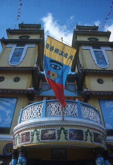 VIETNAM, An Long, Cao Dai Temple.  Detail of front portico and banner featuring the Divine Eye symbol.