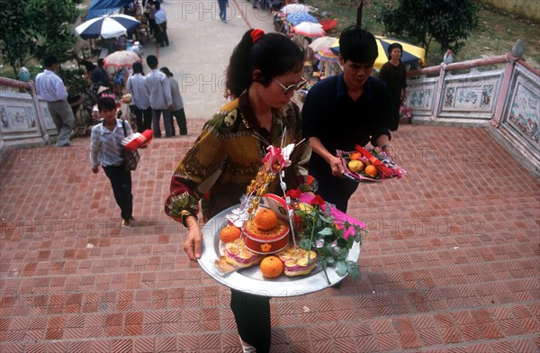 VIETNAM, Den Ba Chua Kho, "People making offerings of fruit, flowers, incense and money at the Money Temple.  "