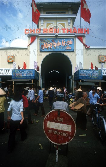 VIETNAM, Ho Chi Minh City, "Main entrance to Ben Thanh Market, part view of belfry and clock, crowds of people. "