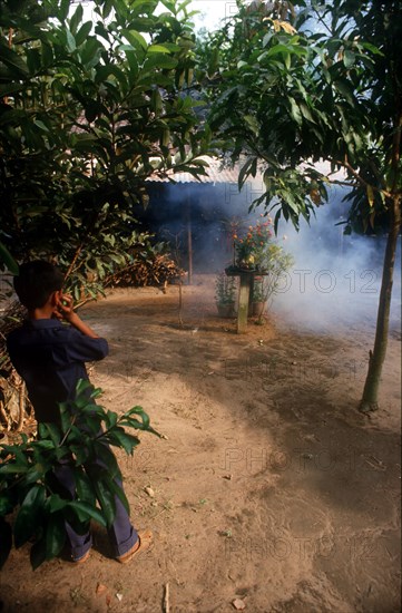 VIETNAM, Ho Chi Minh City, Young boy putting his fingers in his ears to block out the sound of firecrackers during Tet festival.