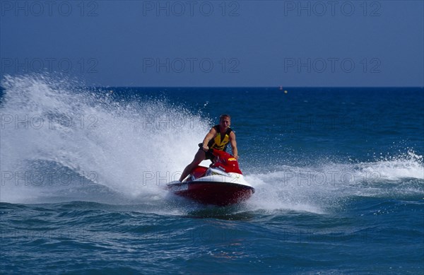 20002914 SPORT Watersports Jet Ski Man riding a jet ski on the sea at Littlehampton in West Sussex  England. Viewed from the front.