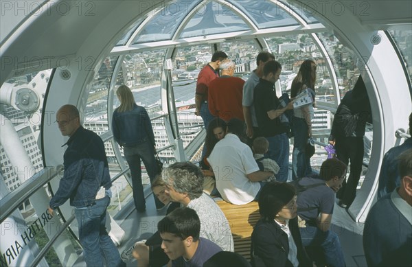ENGLAND, London, British Airways London Eye Milennium wheel interior of capsule with tourists looking over the city