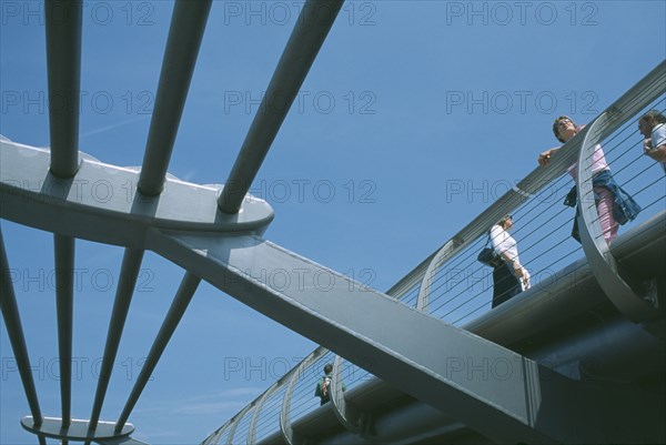 ENGLAND, London, Section of the underside of the Millennium footbridge with pedestrians looking over the side