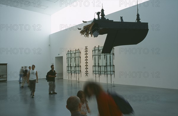 ENGLAND, London, Tate Modern. Modern art exhibition room with piano suspended from the ceiling and visitors