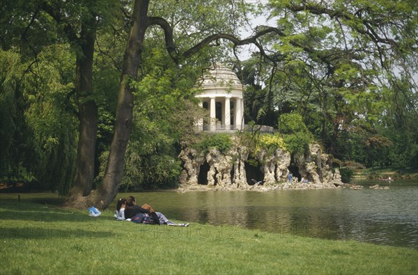 FRANCE, Ile de France, Paris, "Bois de Vincennes, couple on bank of Lake Daumesnil"
