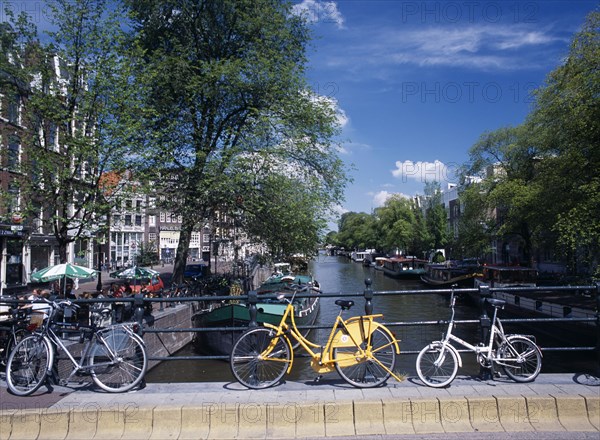 HOLLAND, Noord, Amsterdam, Bicycles leaning against the railings of a bridge over the Prinsengracht canal