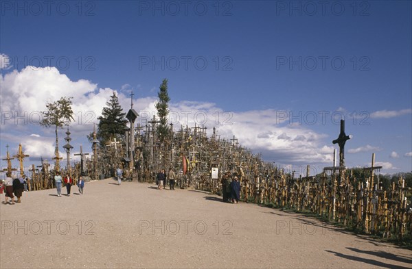 LITHUANIA, Hill of Crosses, "Visitors at ancient pilgrimage site of hill near Siaulial covered with hundreds of crosses, shrines and crucifix."