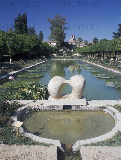 SPAIN, Andalucia, Cordoba, Alcazar de los Reyes Cristianos and its gardens with large pond and modern sculpture in the foreground