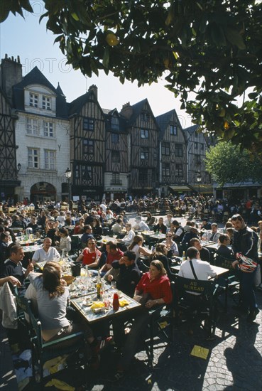 FRANCE, Loire Valley, Indre et loire, Tours Place Plumereau with view over lots of people eating at tables.