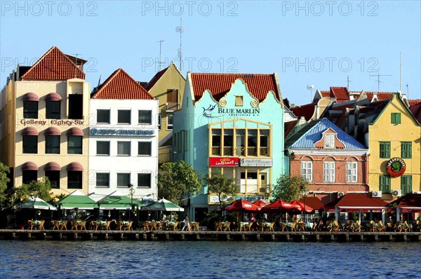 WEST INDIES, Dutch Antilles, Curacao, Old Willemstad. Row of brightly painted waterfront restaurants and cafes
