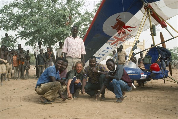 CAMEROON, Explorers, Travel writer and explorer Christina Dodwell with microlight aircraft and group of local men and children.
