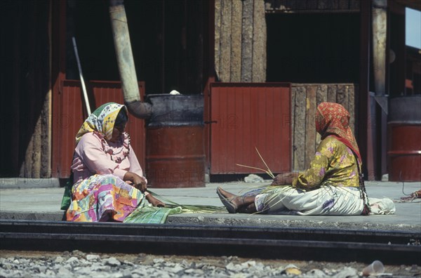 MEXICO, Sierra Madre Occidental, Divisadero Station , Tarahumara Indian women weaving baskets at station on the rim of the Copper Canyon.