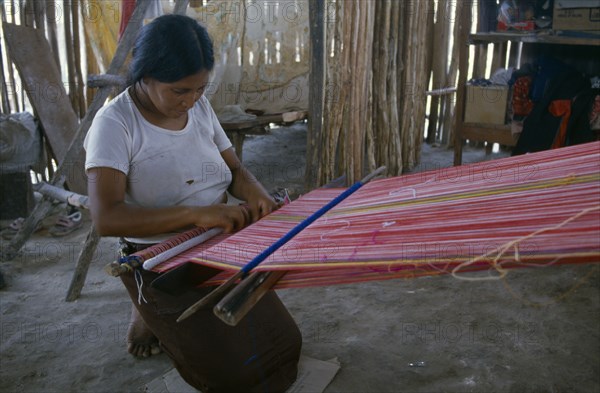 MEXICO, Quintana Roo, Chetumal, Woman weaving textile on hand loom at Los Liros Guatemalan refugee camp.