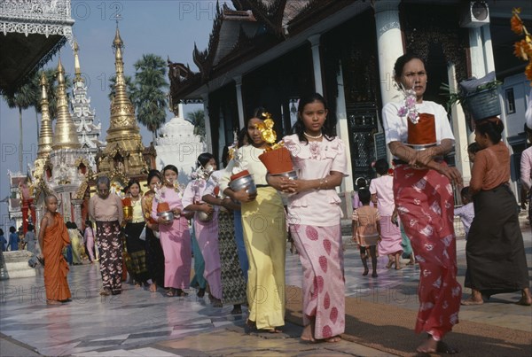 MYANMAR, Yangon, Shwedagon Pagoda.  Line of young women with offerings.