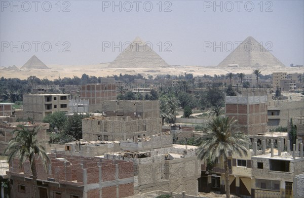 EGYPT, Cairo, City suburbs encroaching on the Pyramids at Giza.