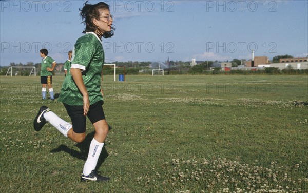 SPORT, Ball Games, Football, Girl playing football with boys in same team standing behind her.