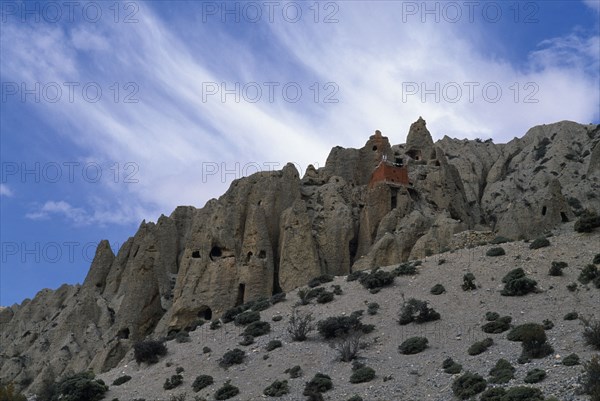 NEPAL, Mustang, Lori Gompa Caves  with small red building atop