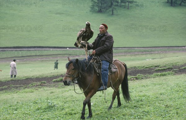 CHINA, Xinjiang Province, Kazakhs, Kazakh falconer on horeseback with eagle used for hunting